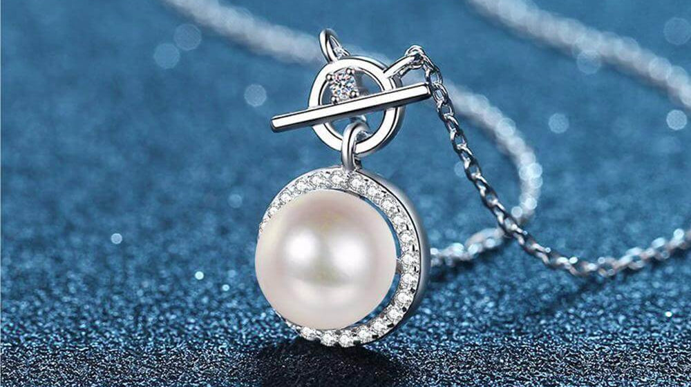 A single pearl necklace adorns a casual look